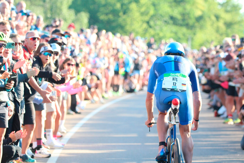 Cyclist surrounded by a large crowd during Challenge Roth. Image via picdrop.com
