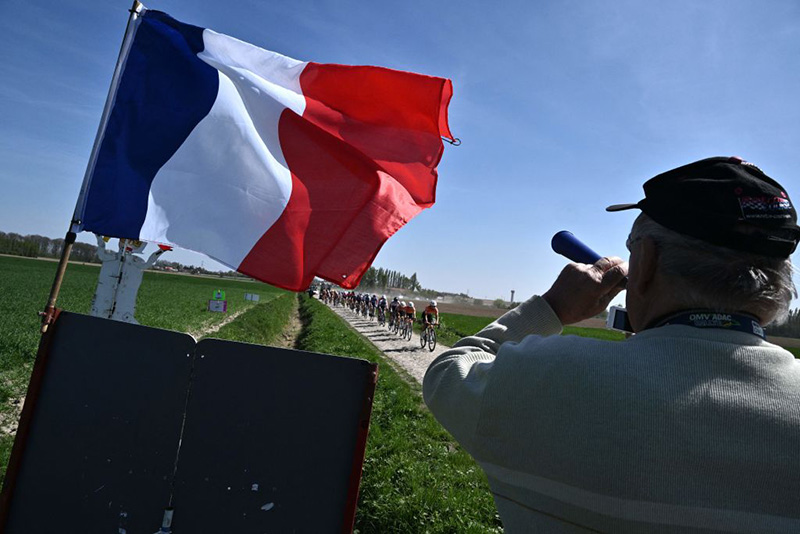 A supporter cheers the riders during Paris-Roubaix one-day classic cycling race, between Denain and Roubaix. Photo by JEFF PACHOUD/AFP via Getty Images.