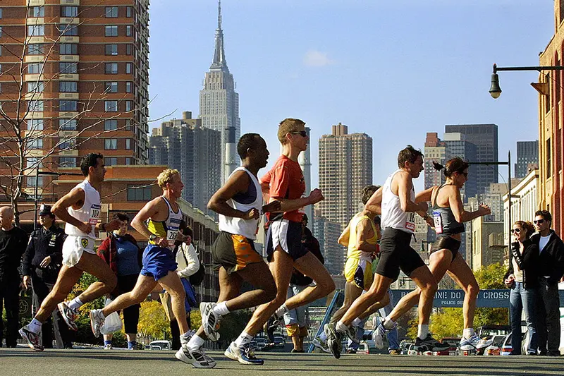 A group of runners passes through Queens during the 32nd New York City Marathon November 4, 2001. The Empire State Building is seen in the background. (Photo by Mario Tama/Getty Images)