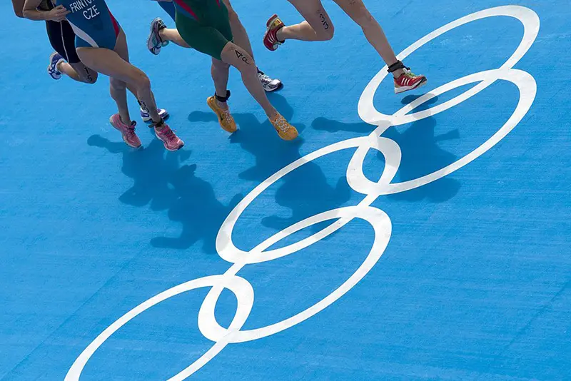 Athletes runs past the Olympic rings painted on the ground during the triathlon on Day 8 of the London 2012 Olympic Games. Photo credit BEN STANSALL/AFP/GettyImages